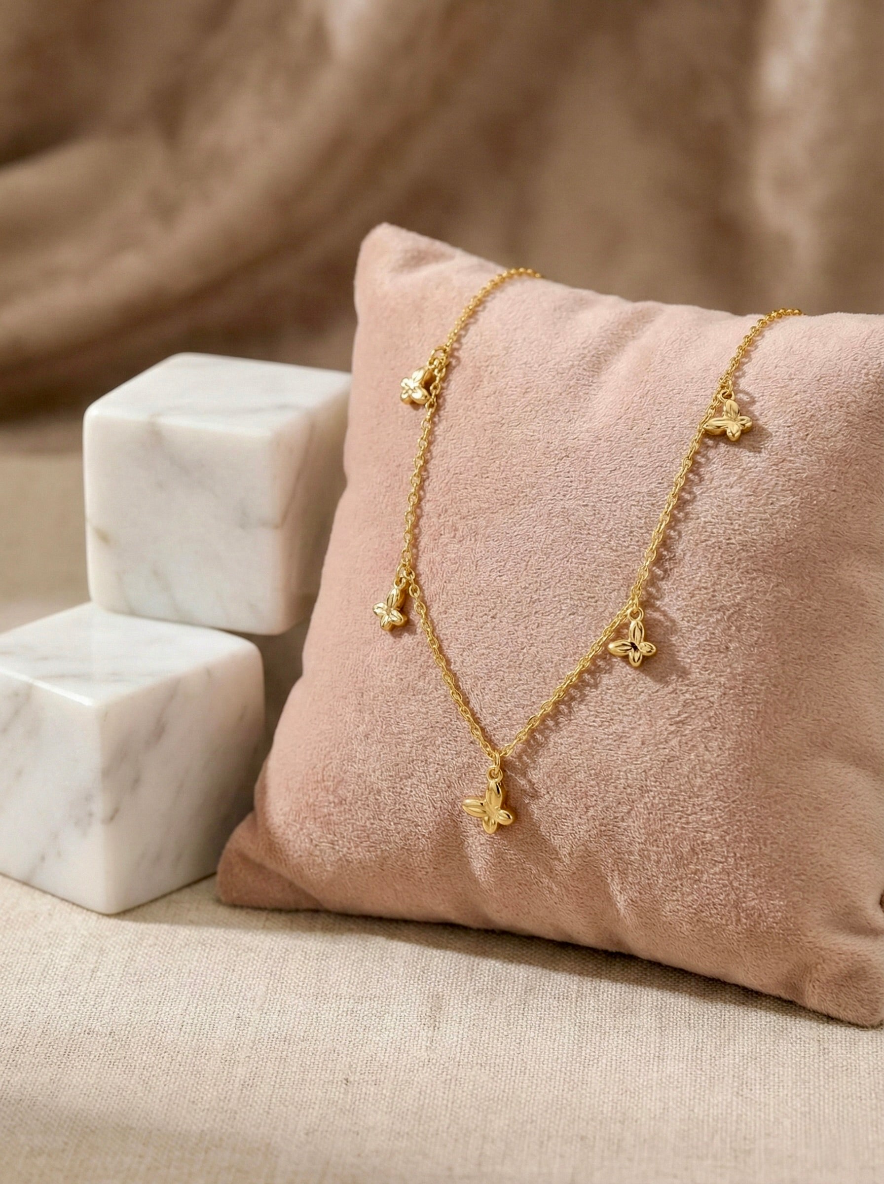 Side view of anti-tarnish gold elara butterfly charm necklace with delicate chain links