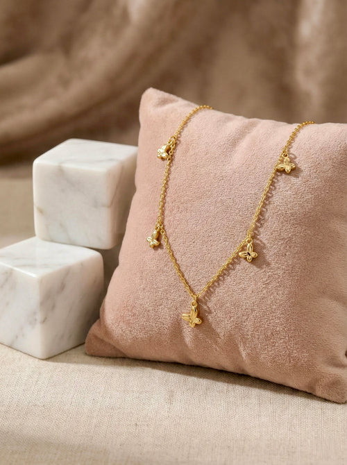 Side view of anti-tarnish gold elara butterfly charm necklace with delicate chain links