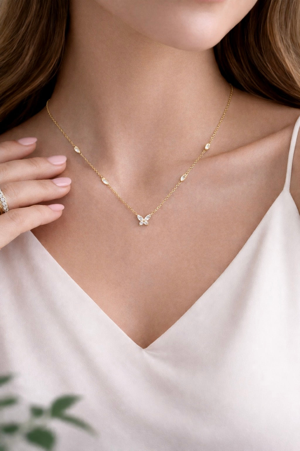 Front view of anti-tarnish gold elira butterfly necklace with delicate chain and stone accents on model