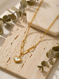 Close-up of white enamel heart pendant on gold anti-tarnish necklace
