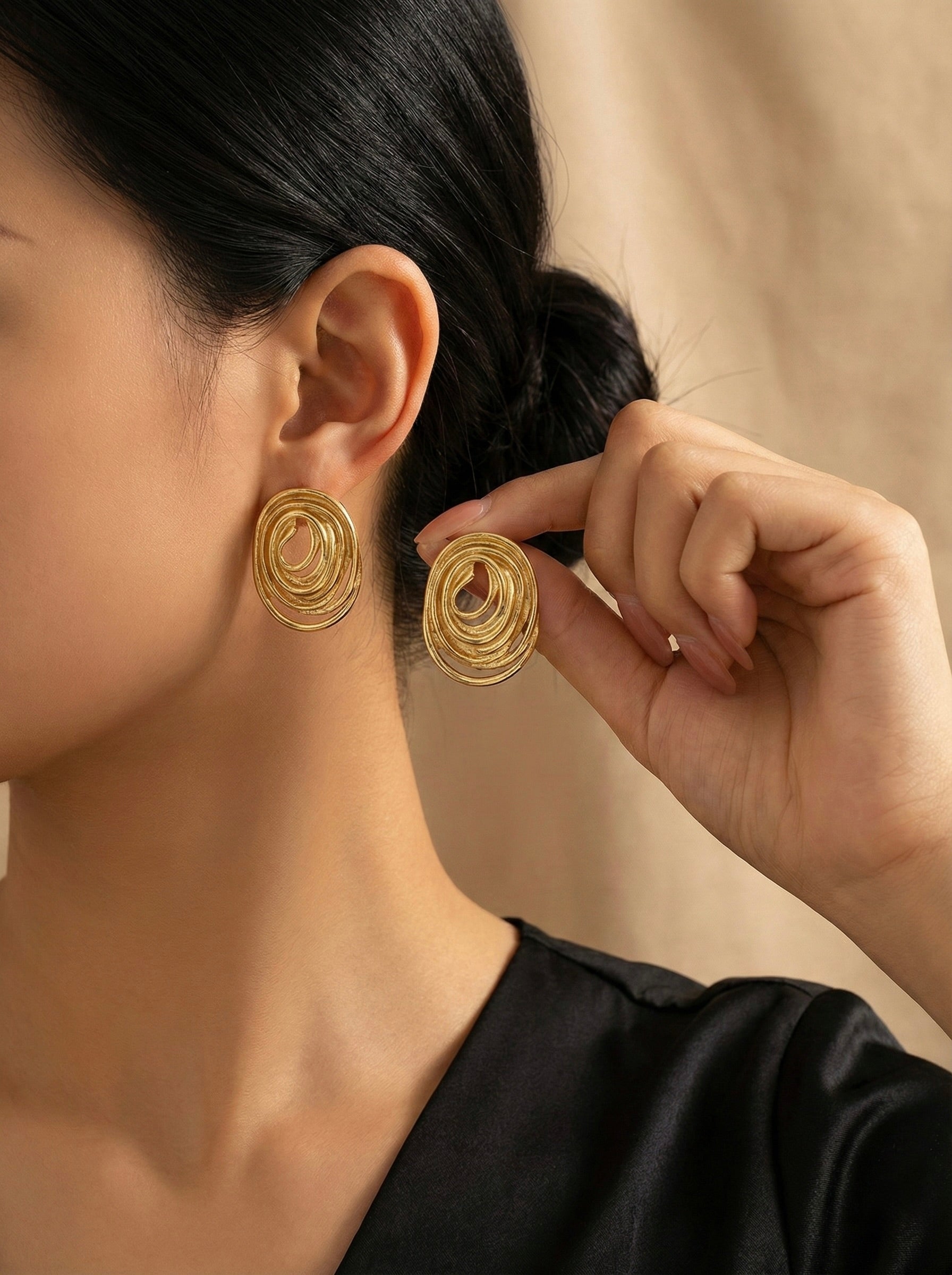Aurelia Swirl gold studs worn on model styled for casual and evening wear