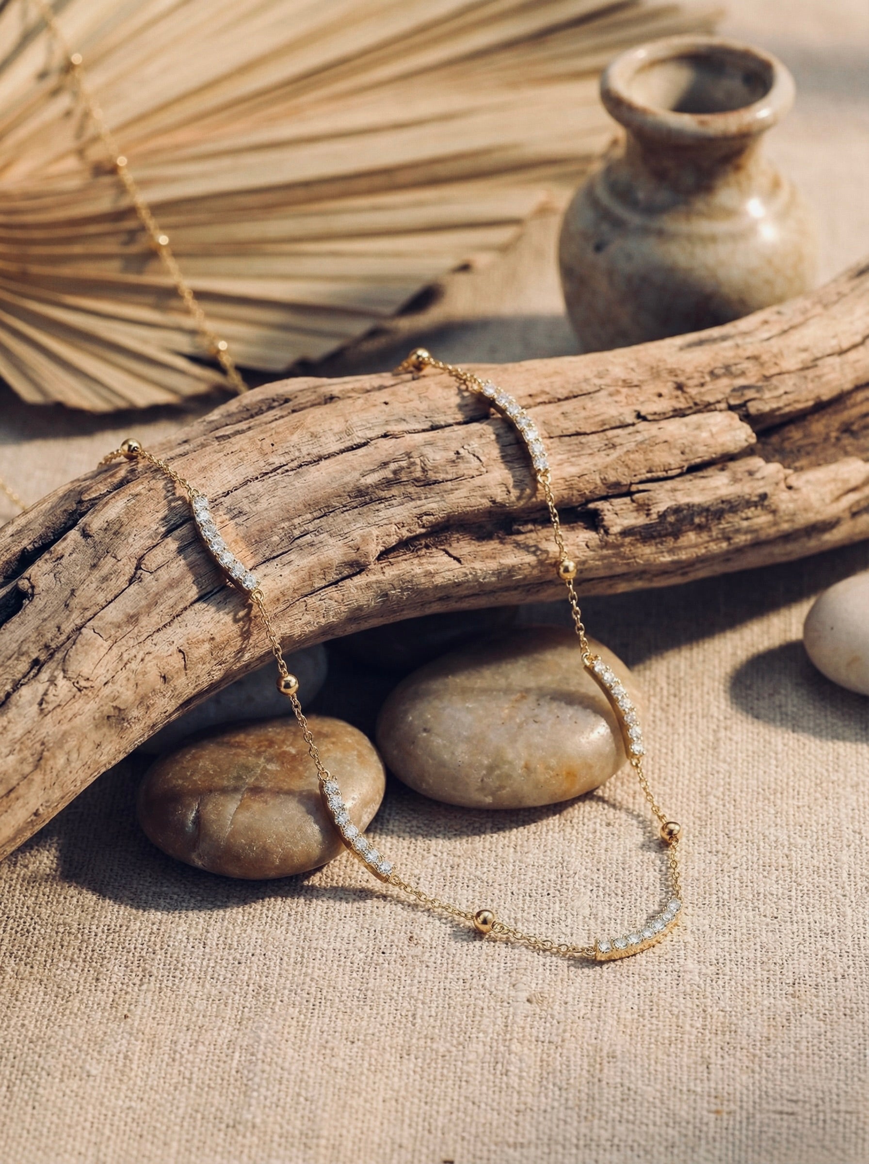 Close-up of sparkling cubic zirconia stones on gold caelisse curve pendant necklace