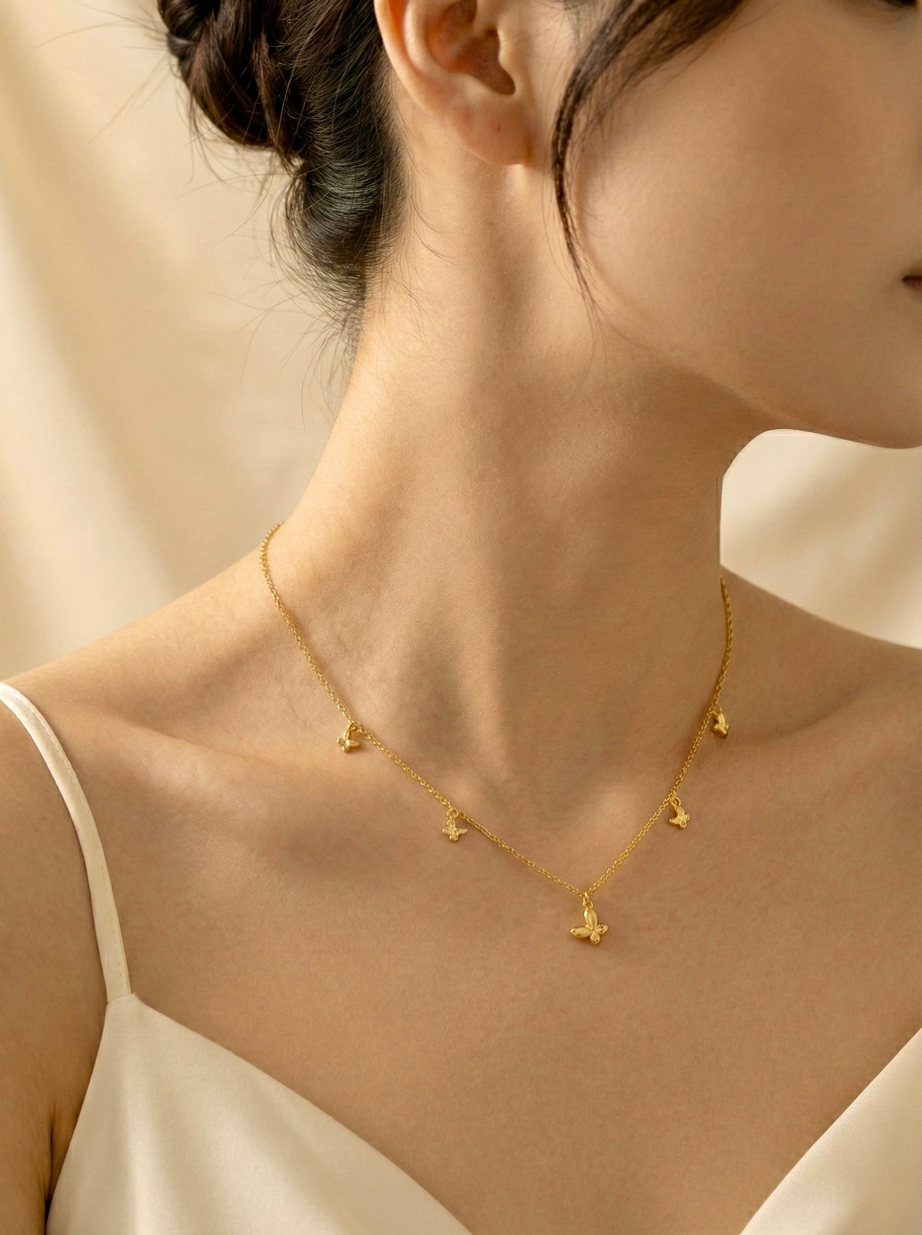 model wearing Elara butterfly gold charm necklace by Sajheera