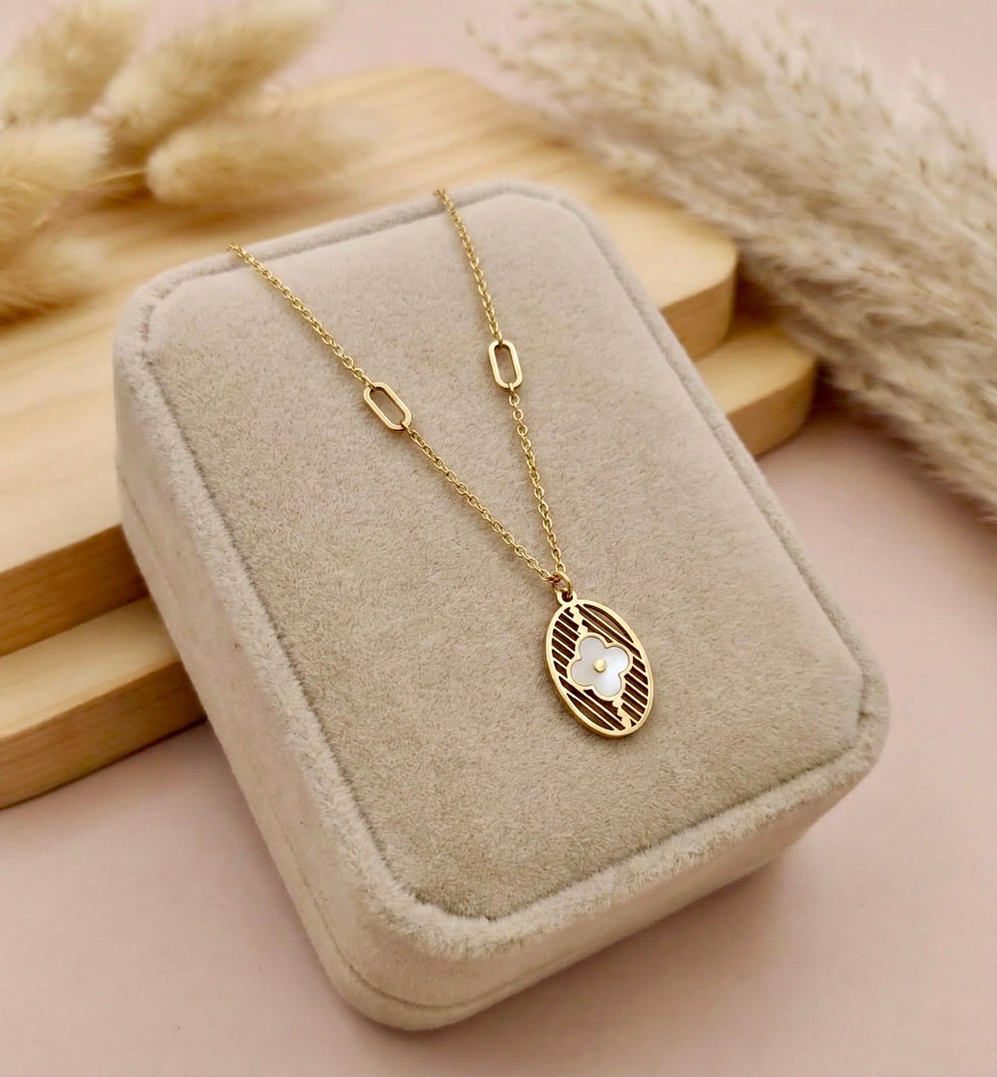 Close-up of floral eliora medallion gold pendant necklace with textured detailing