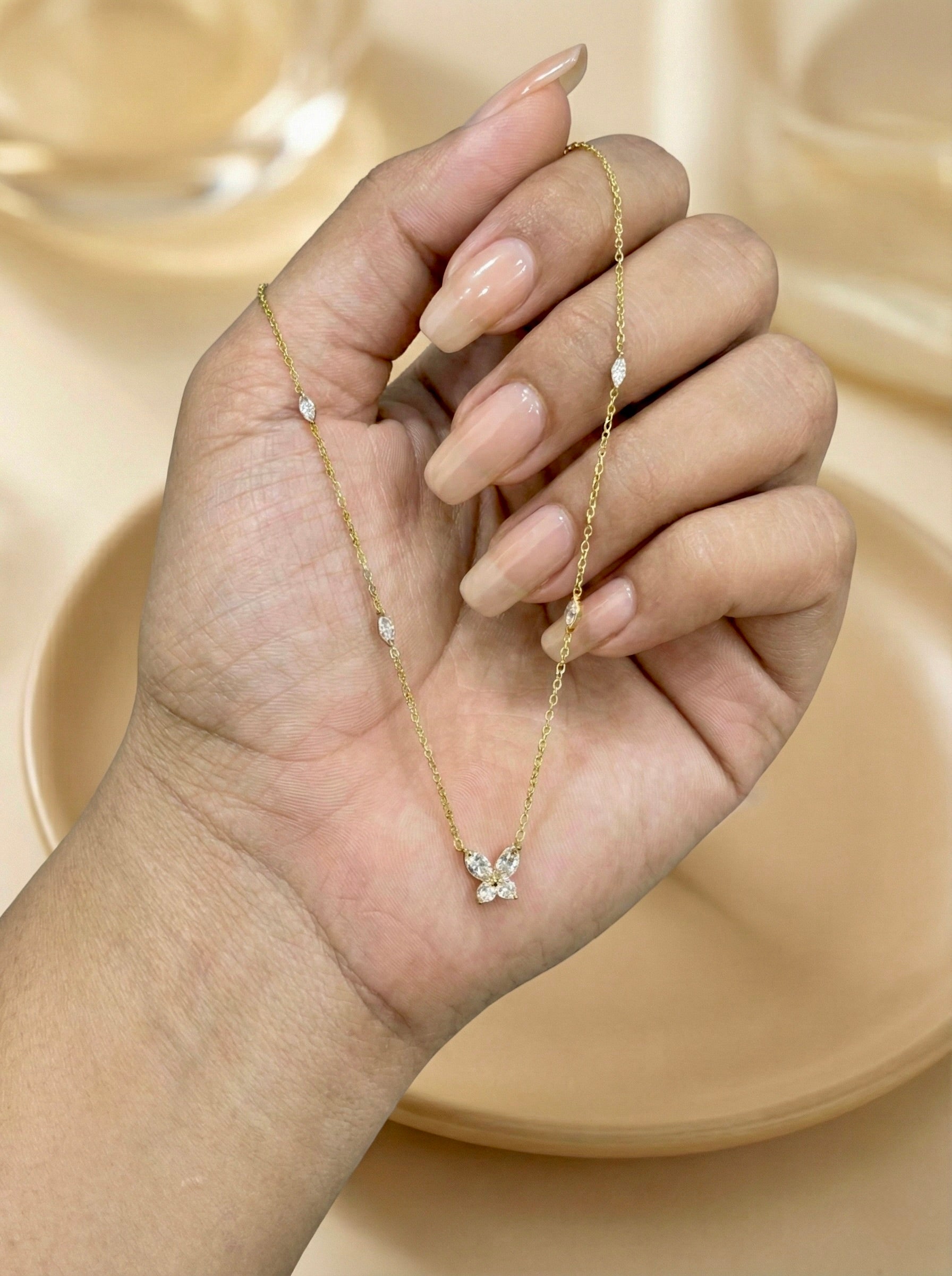 Close-up of gold elira butterfly charm necklace with cubic zirconia sparkle