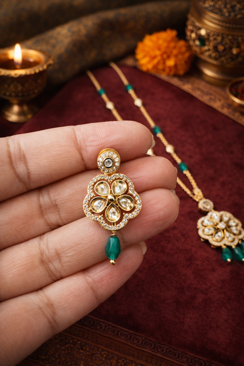 Front Close view of Emerald Pushpa Grace kundan earrings in model's hand