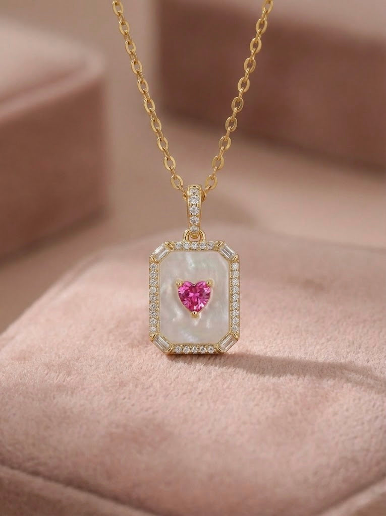 Close-up details of crimson red/pink heart stone halo pendant necklace with sparkling CZ border in gold