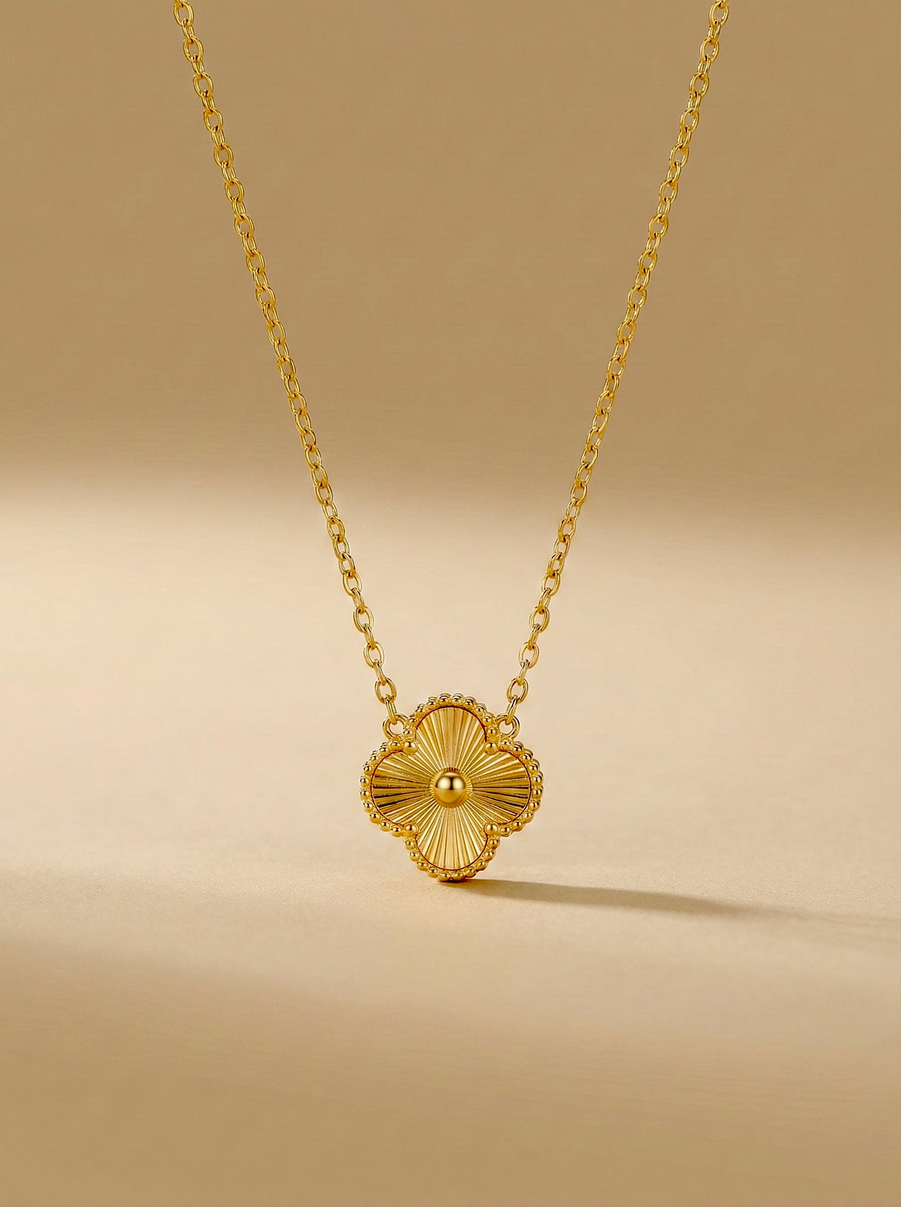 Front view of anti-tarnish gold Florielle clover charm necklace with delicate chain