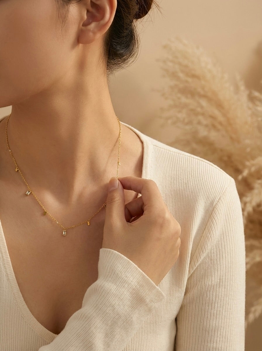 Lumera Quad anti-tarnish gold crystal station necklace styled on a model for everyday wear