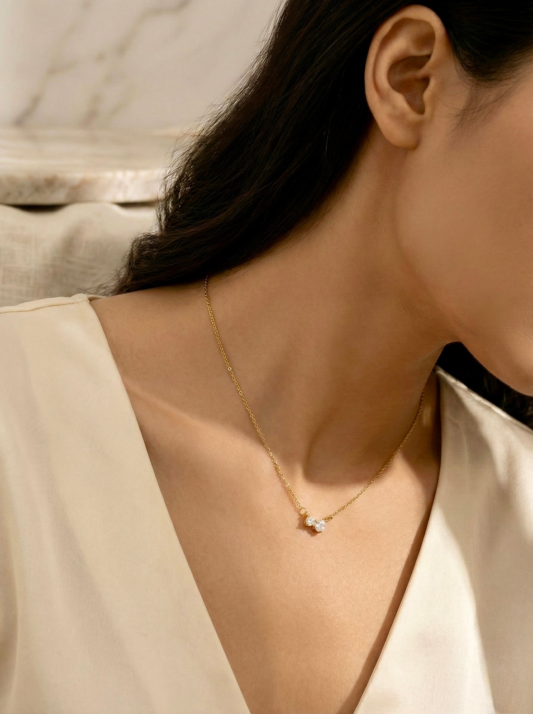 Lunara gold lunara bow CZ pendant necklace with anti-tarnish finish with minimal chain styled on model for everyday elegance