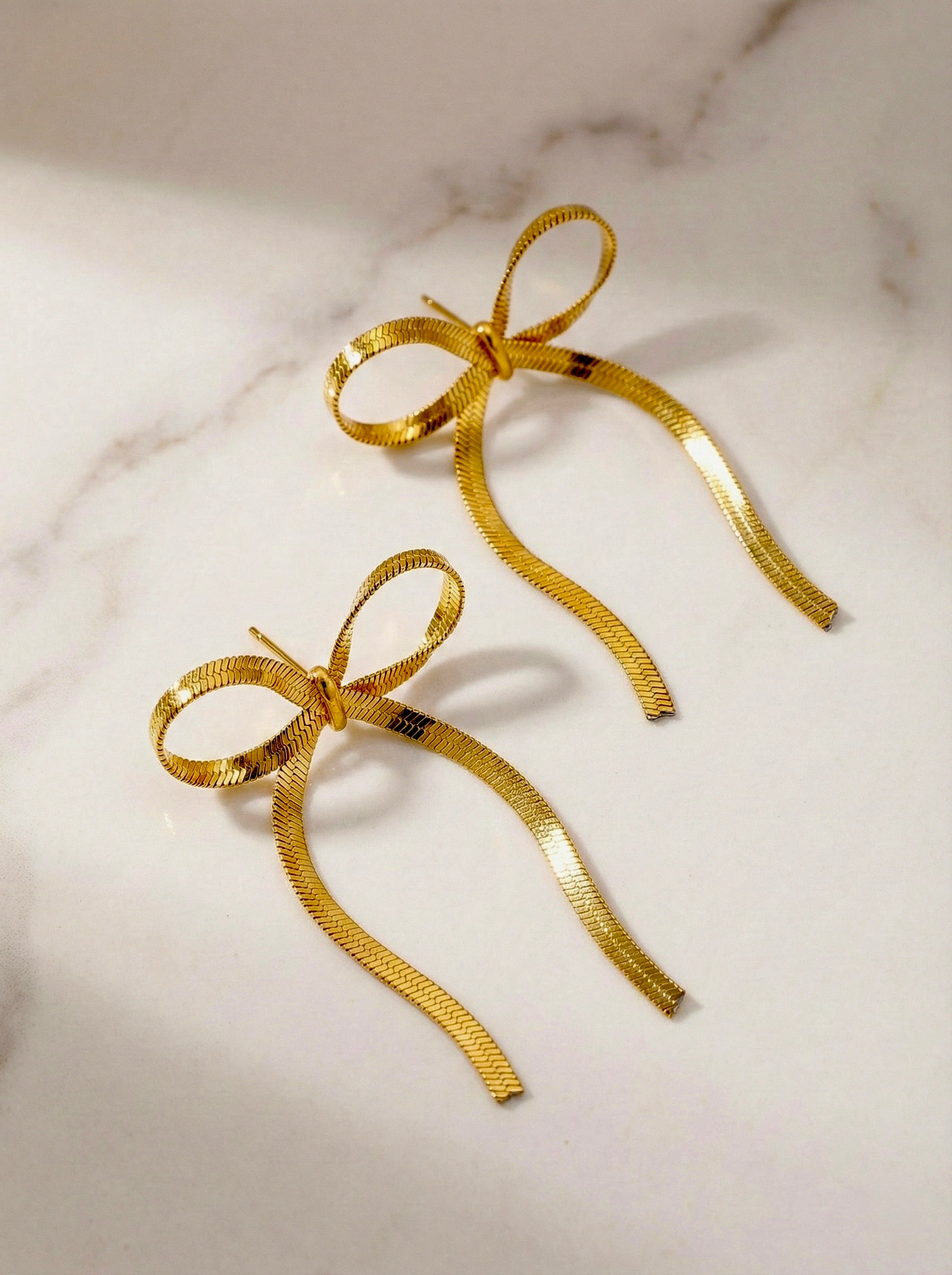 Minimal gold bow drop earrings styled with outfit for brunch