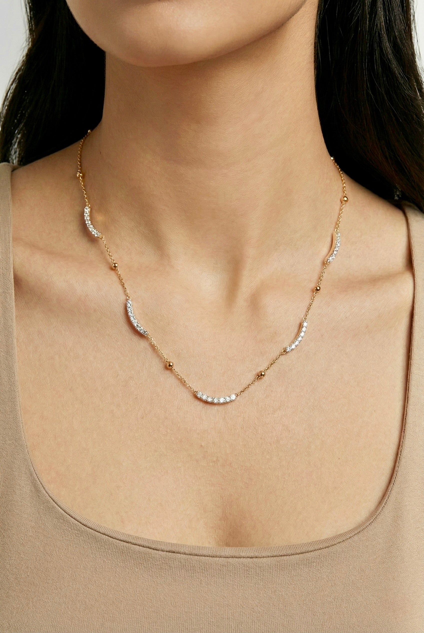 Minimal gold caelisse curve CZ necklace styled on model for everyday elegance