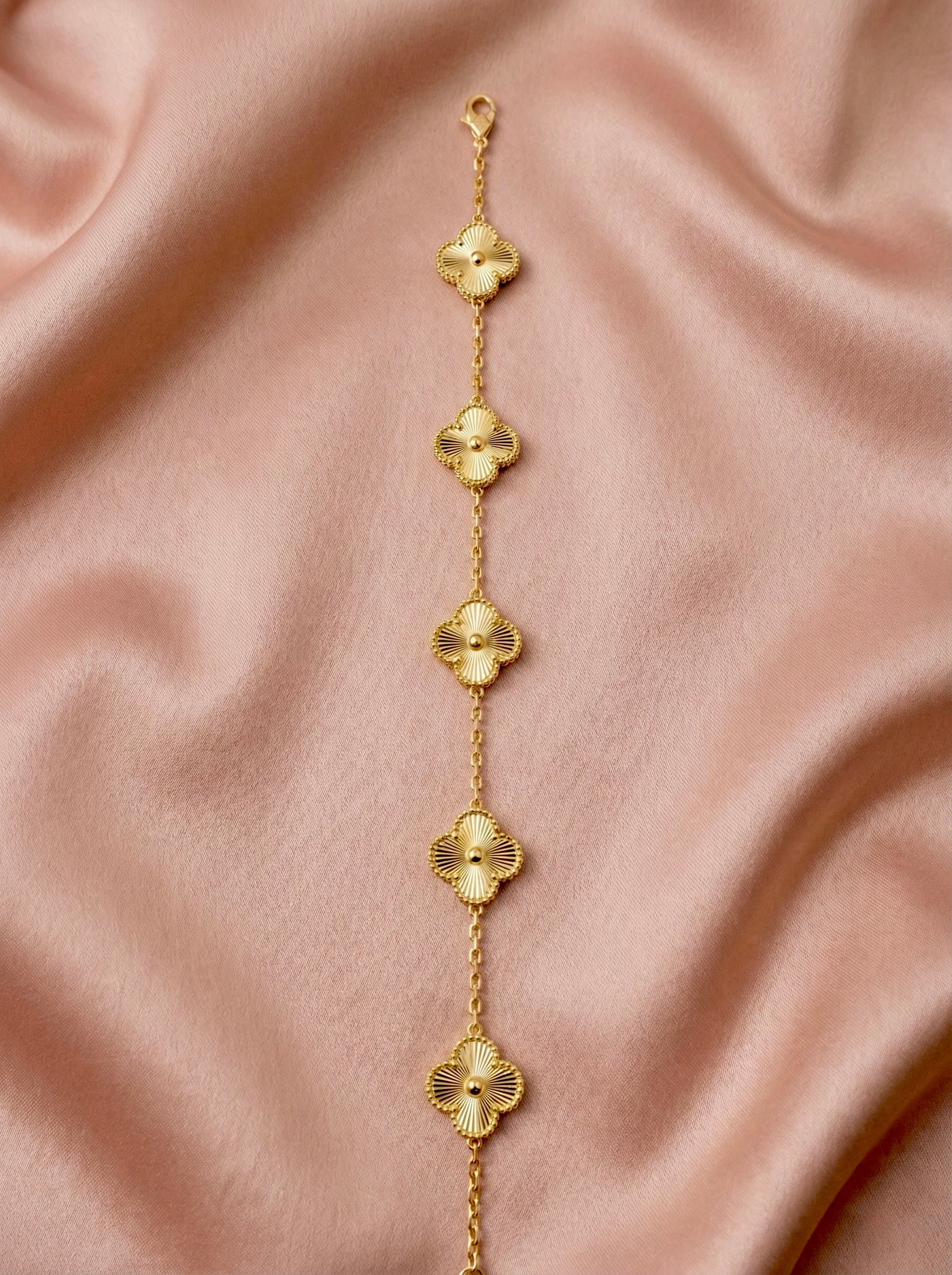 Minimal gold clover charm bracelet styled in gift box for everyday elegance