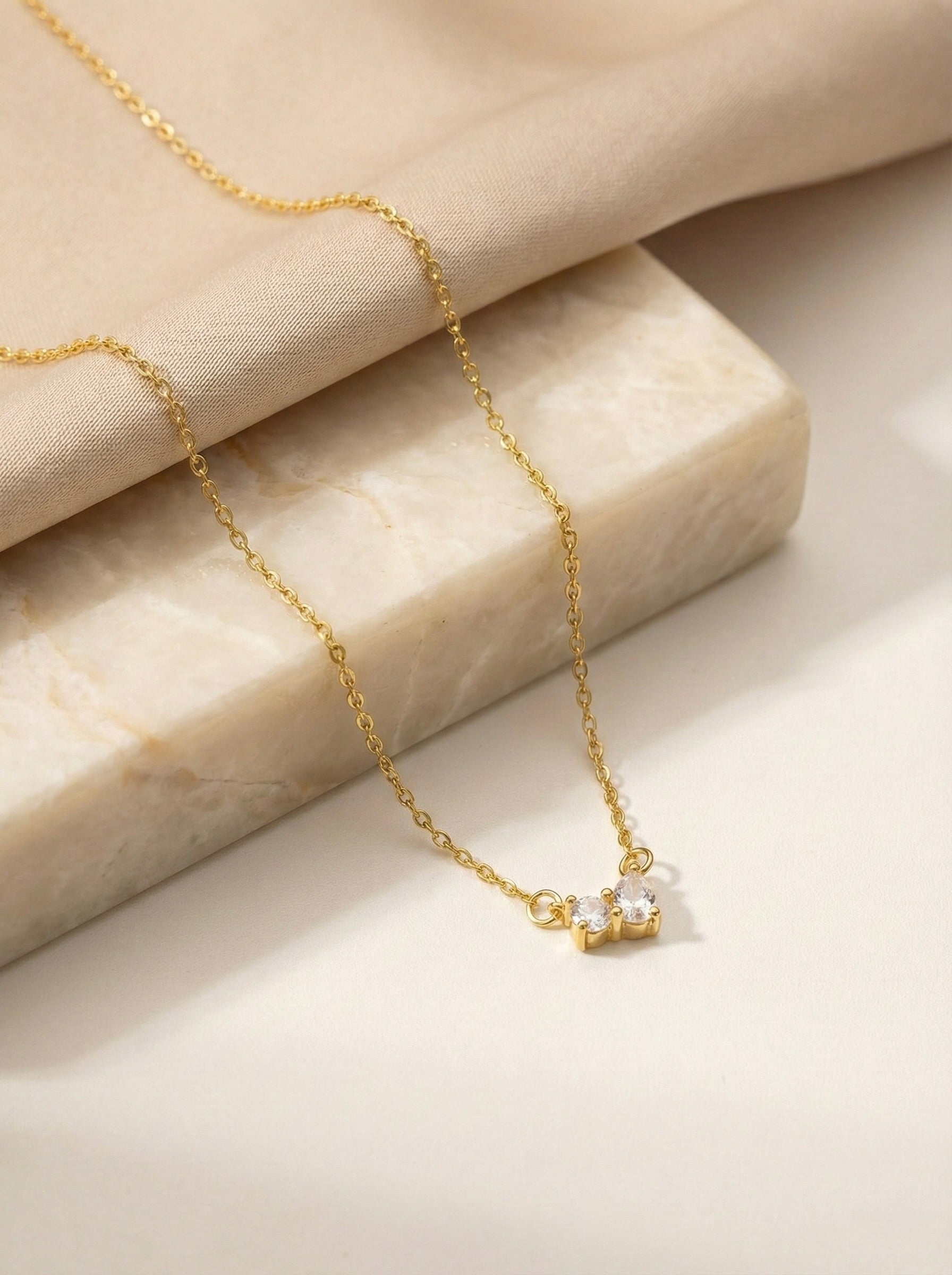 Minimal gold lunara bow pendant necklace styled for everyday elegance