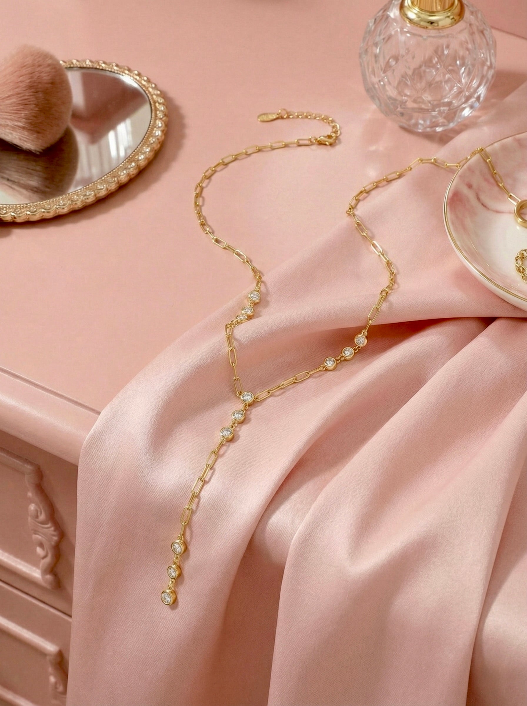 Minimal gold CZ station necklace styled on neutral surface for everyday elegance