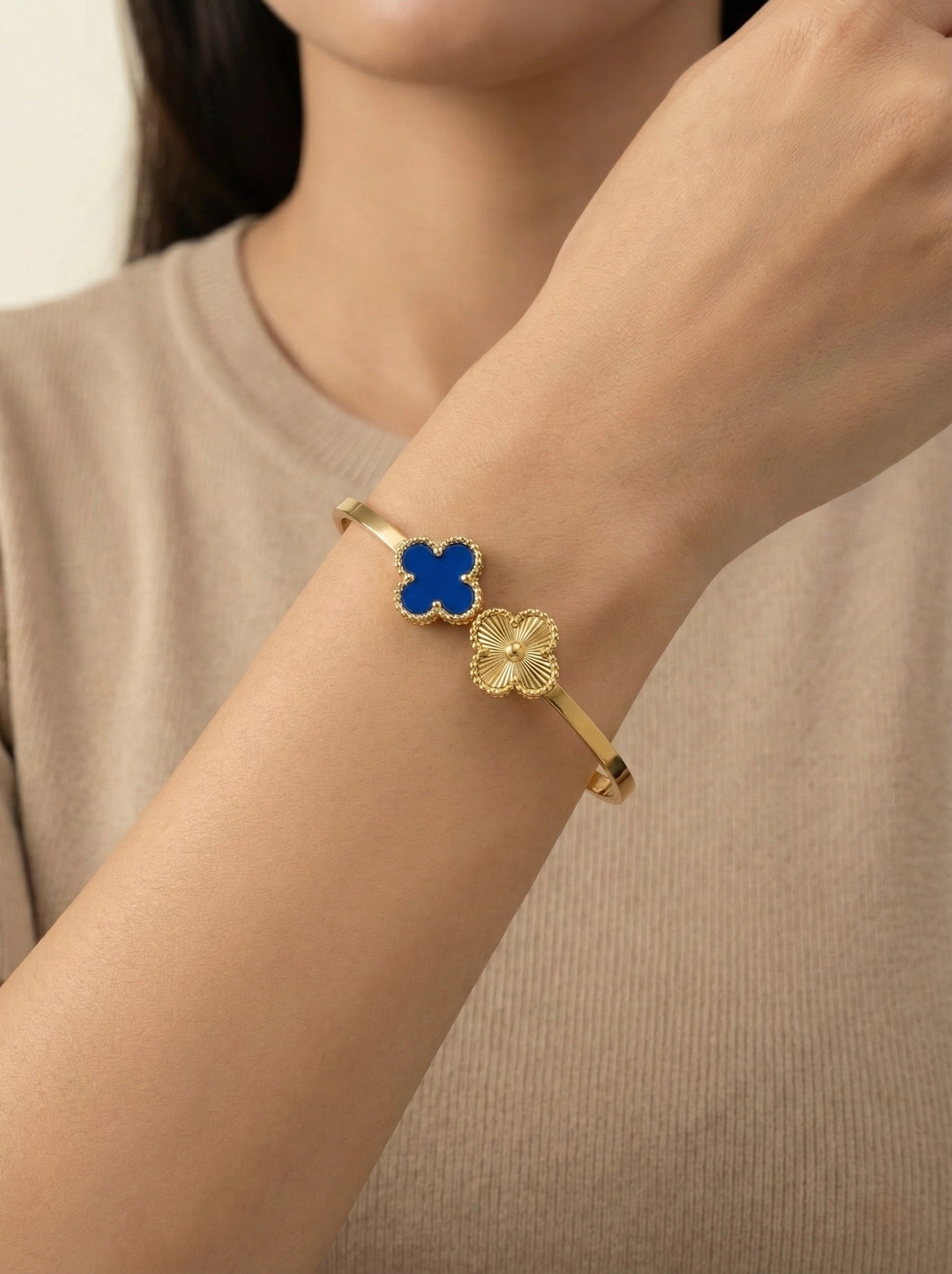 Close-up of Nolira twin clover gold cuff bracelet showing enamel and polished clover charms