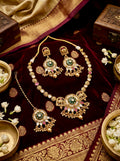 Antique gold-plated temple jewellery set featuring green meenakari work and elephant motifs, including necklace, earrings, and maang tikka.