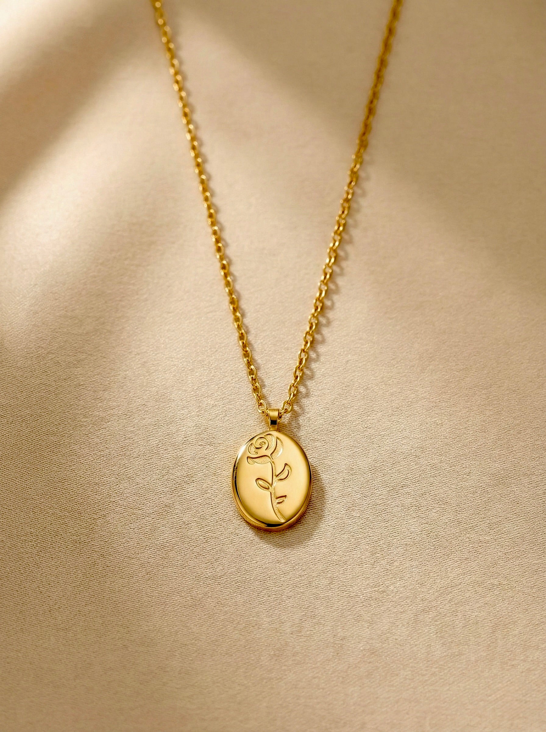 Close-up of Roseline gold necklace showing engraved rose oval pendant