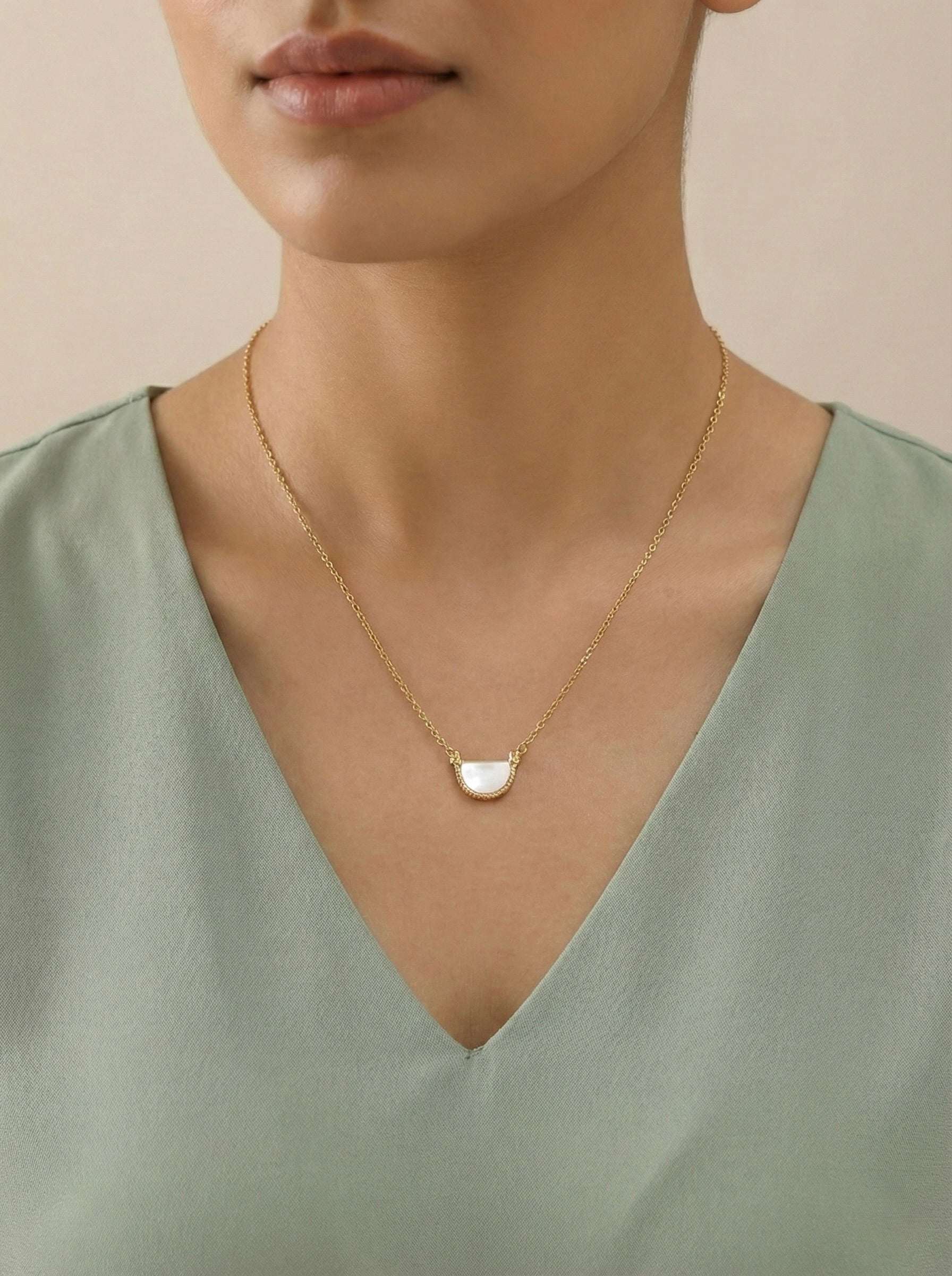 Sparkling minimal Arvella arc pendant necklace on model with casual outfit