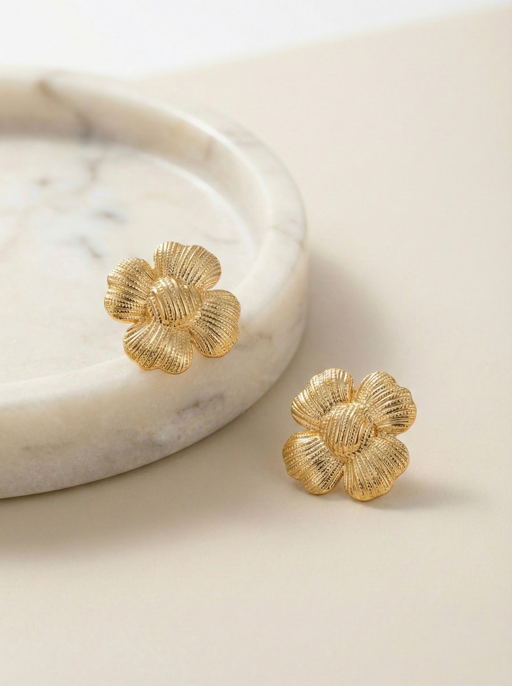 Side view of The Bloom Studs textured gold floral statement stud earrings
