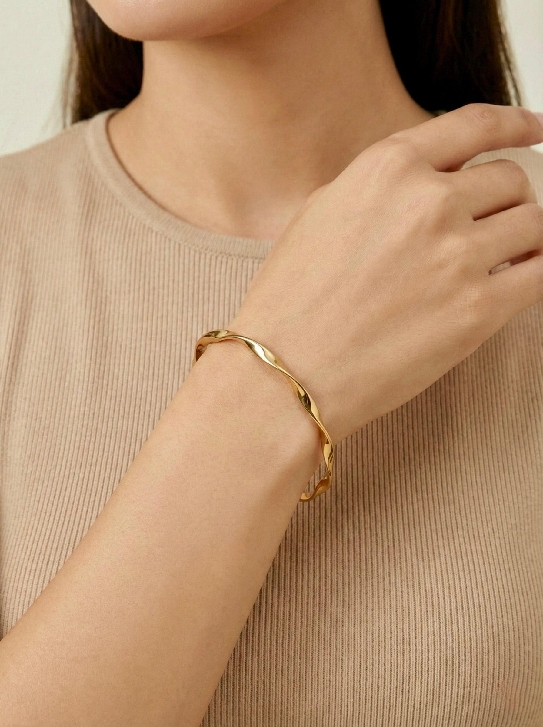 Close-up of Twylia Twist anti-tarnish gold bracelet bangle showing twisted design om model's wrist