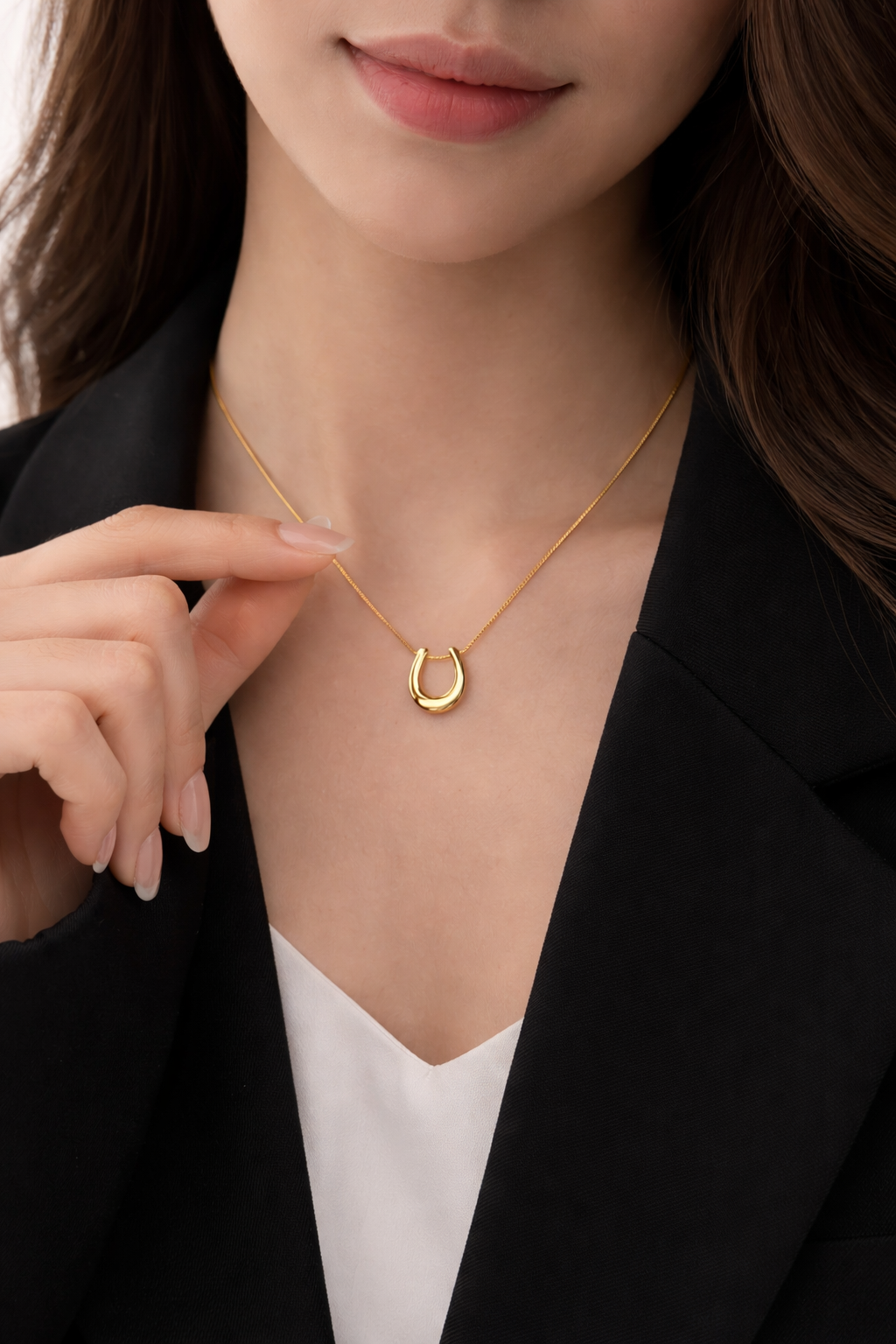 Minimal gold U-shaped pendant necklace worn for everyday elegance