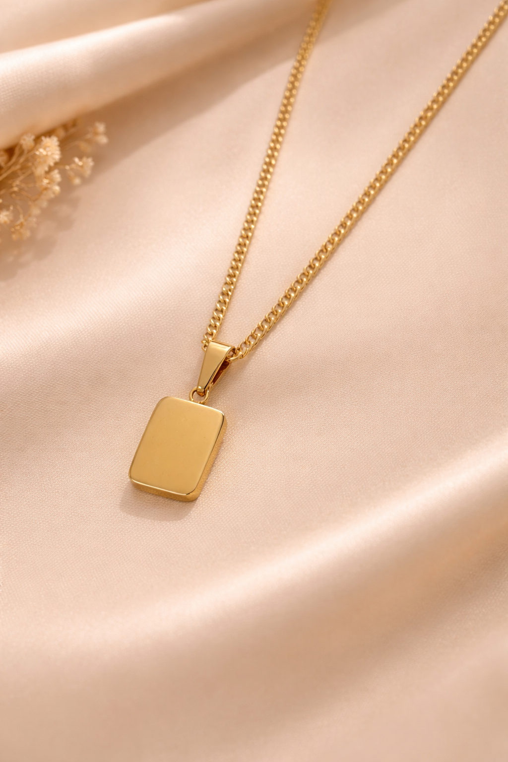 Close-up of green rectangular stone pendant on gold anti-tarnish necklace